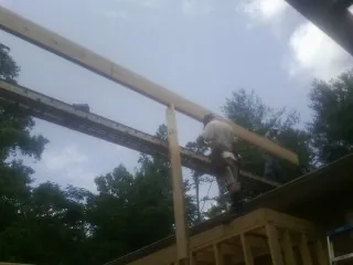 Carpenter setting a ridge beam over a new addition frame — Ice Dam Removal by Roofing Brothers in Hyde Park