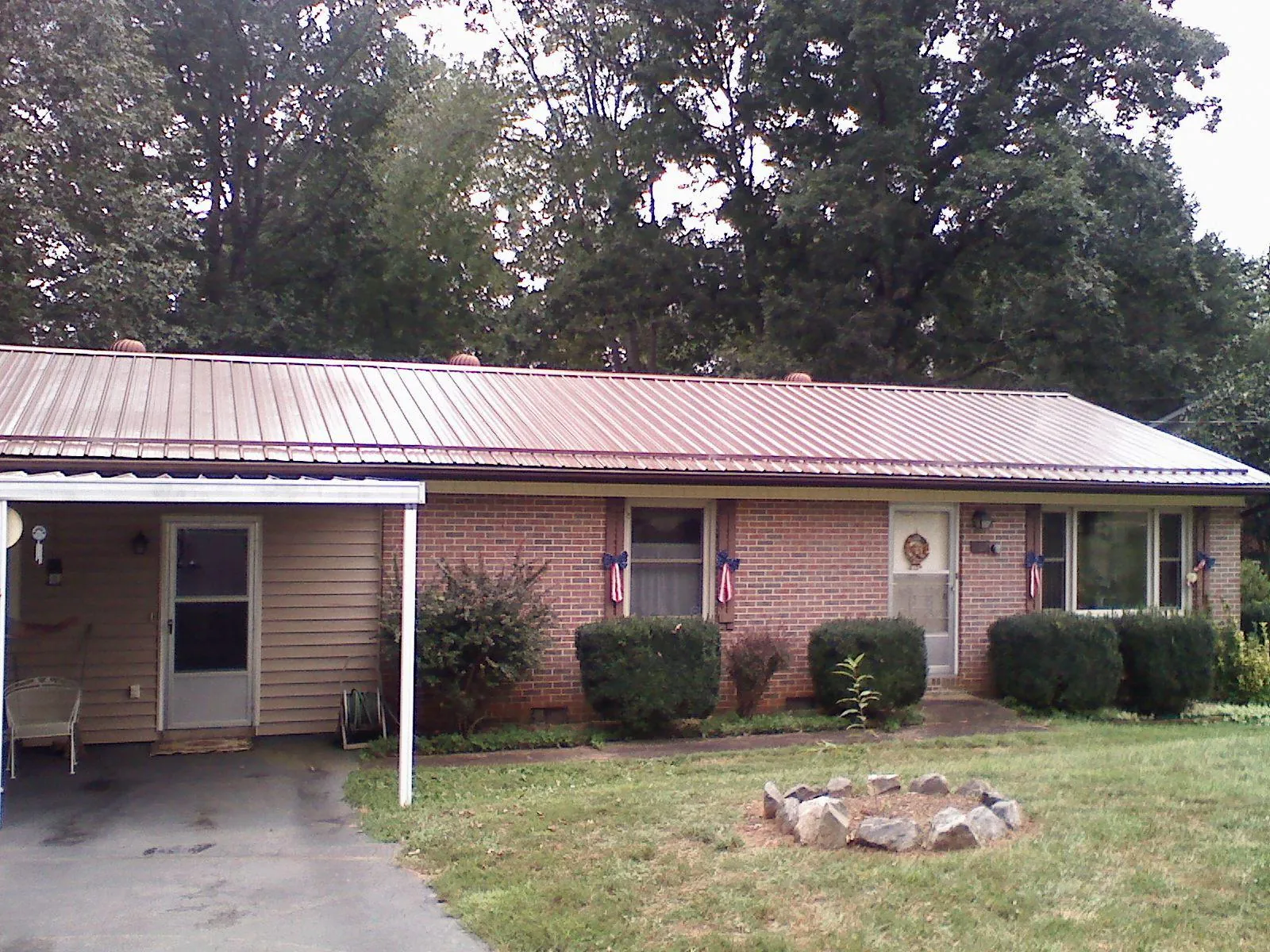 Bronze metal roof and carport on a brick ranch home — Roof Repair work by our crew in Hyde Park